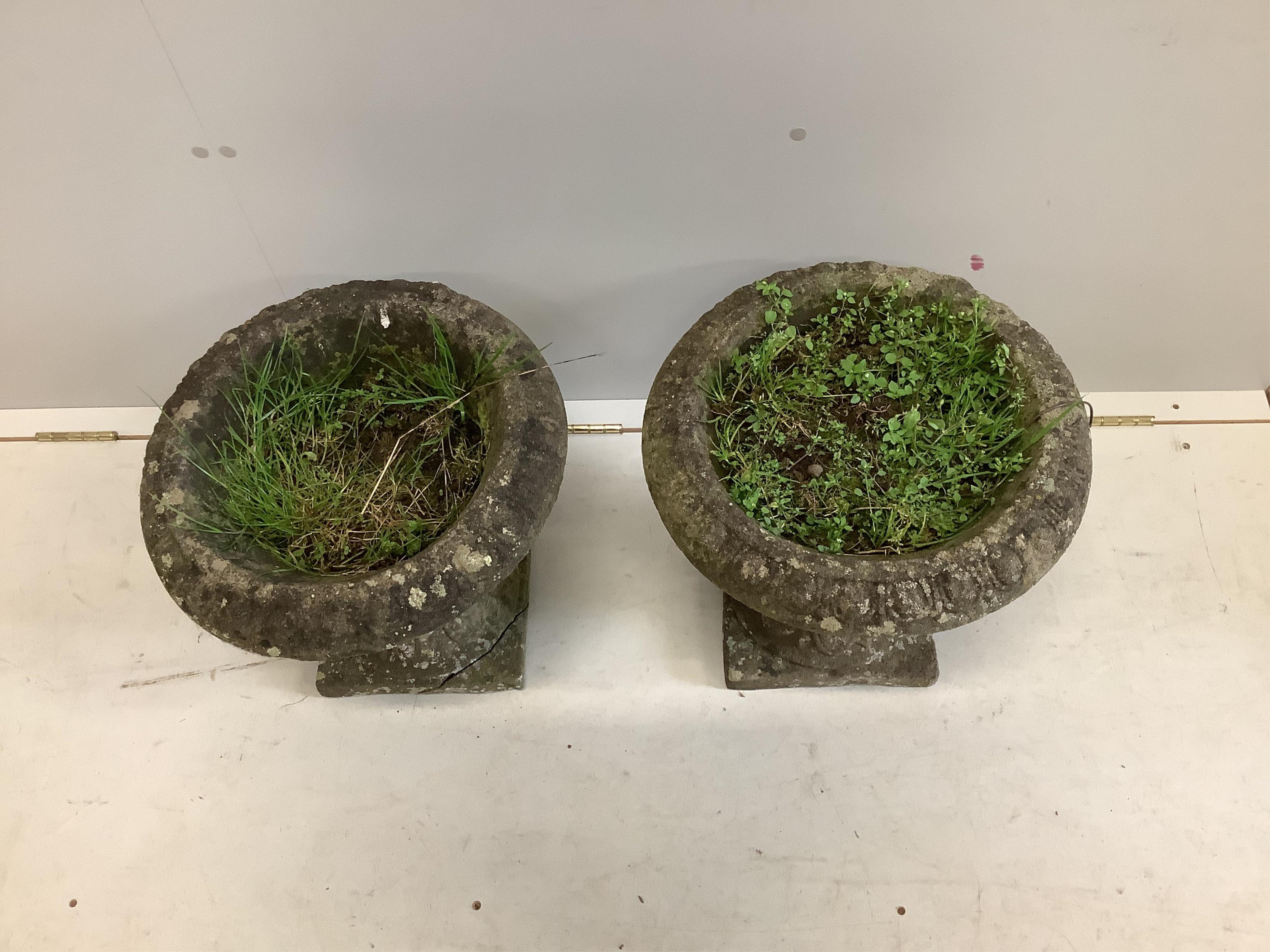 A pair of reconstituted stone circular campana garden urns, diameter 40cm, height 38cm. Condition - poor to fair